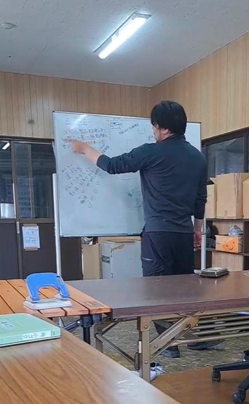 ホワイトボードの前に立つ男性